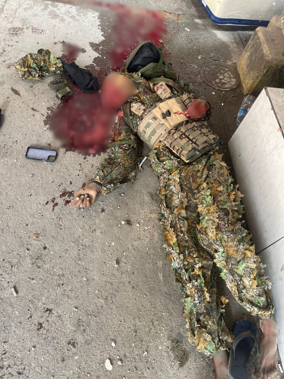 Mulher com roupas camufladas e colete tático caída no chão após confronto, identificada como Japinha do CV. (Reprodução)